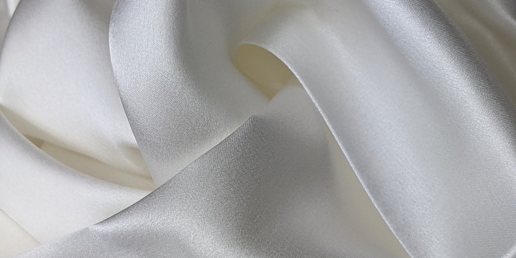 Folded white silk textile collection banner